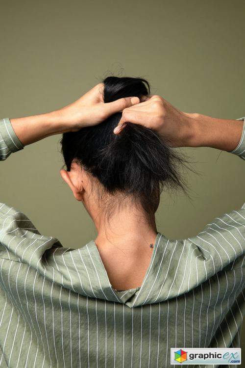  Rear view of a woman putting her long hair up 