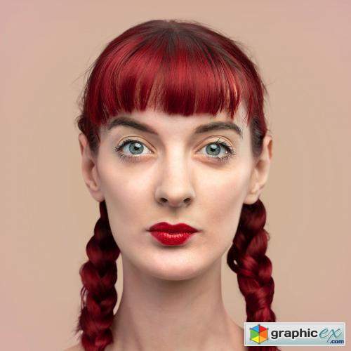 Portrait of beautiful woman with braided red hair on a blank beige wall